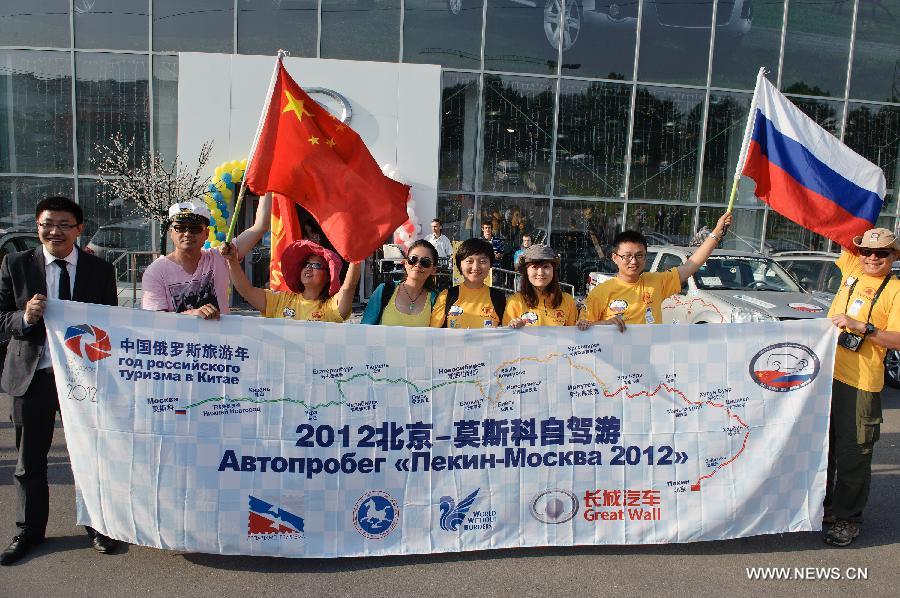 Participants of the Beijing-Moscow Self-Driving Tour pose for a group photo upon arrival in Moscow, capital of Russia, July 2, 2012. The China-Russia cooperation in tourism has substantially progressed, which also has promoted bilateral understandings and exchange of culture in recent years. The Year of Chinese Tourism in Russia in 2013 will be inaugurated by Chinese President Xi Jinping when he visits Moscow later this month. (Xinhua/Jiang Kehong)