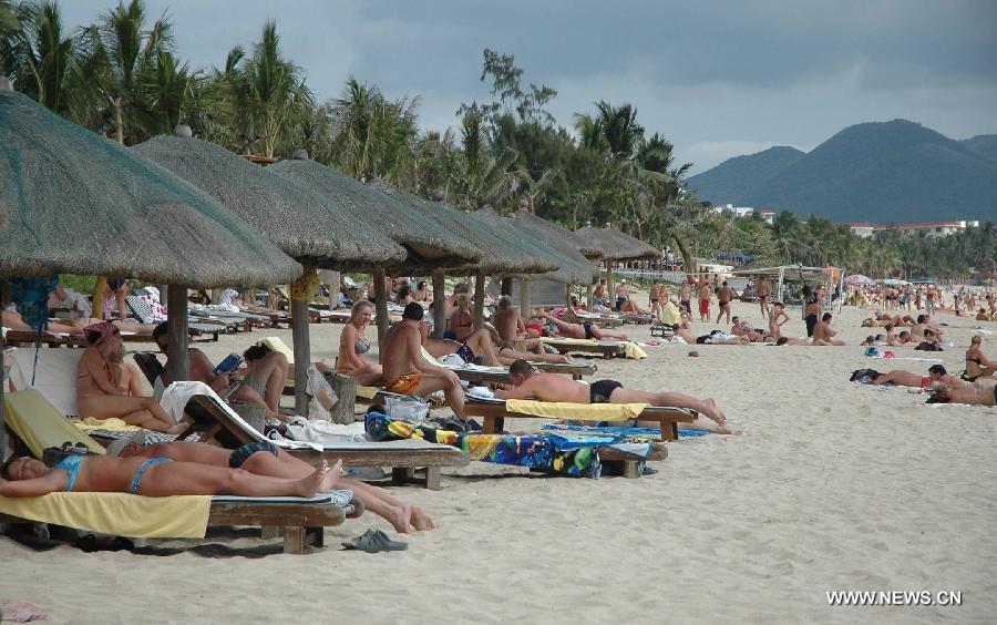 Russian tourists enjoy sunshine at a beach in Sanya, a coastal resort of south China's island province of Hainan, Jan. 4, 2007. The China-Russia cooperation in tourism has substantially progressed, which also has promoted bilateral understandings and exchange of culture in recent years. The Year of Chinese Tourism in Russia in 2013 will be inaugurated by Chinese President Xi Jinping when he visits Moscow later this month. (Xinhua/Huang Ju)