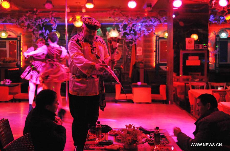 Eremin Sergei presents Russian customs and sells flowers to visitors on Vasil Russian Street in Harbin, capital of northeast China's Heilongjiang Province, March 16, 2013.(Xinhua/Wang Jianwei) 