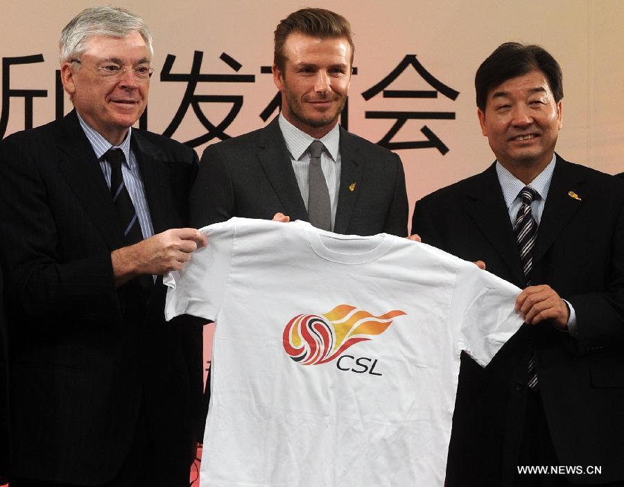 British footballer David Beckham (C) holds up a CSL souvenir T-shirt during a press conference in Beijing, capital of China, on March 20, 2013. David Beckham came to China as the ambassador for the youth football program in China and the Chinese Super League (CSL). (Xinhua/Gong Lei) 