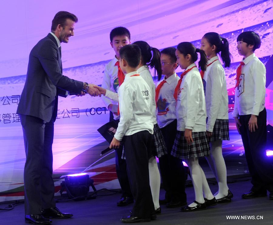 British footballer David Beckham (L) shakes hands with the children during a press conference held at a primary school in Beijing, capital of China, on March 20, 2013. David Beckham came China as Ambassador for the Youth Football Programme in China and the Chinese Super League (CSL). (Xinhua/Gong Lei)