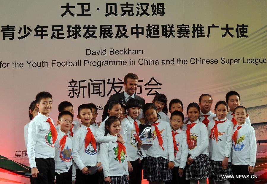 British footballer David Beckham (Back) poses with the children for a photo during a press conference in Beijing, capital of China, on March 20, 2013. David Beckham came to China as the ambassador for the youth football program in China and the Chinese Super League (CSL). (Xinhua/Gong Lei) 