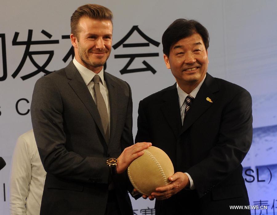 British footballer David Beckham (L) gets a gift from Wei Jixiang, secretary of the Football Management Center of General Administration of Sport of China, during a press conference in Beijing, capital of China, on March 20, 2013. David Beckham came China as Ambassador for the Youth Football Programme in China and the Chinese Super League (CSL). (Xinhua/Gong Lei)