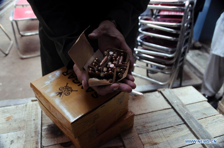 A policeman displays seized bullets to media at a police station in northwest Pakistan's Peshawar on March 19, 2013. Police arrested two suspects who tried to smuggle weapons and ammunitions from Peshawar to Punjab province, local media reported. (Xinhua/Ahmad Sidique) 