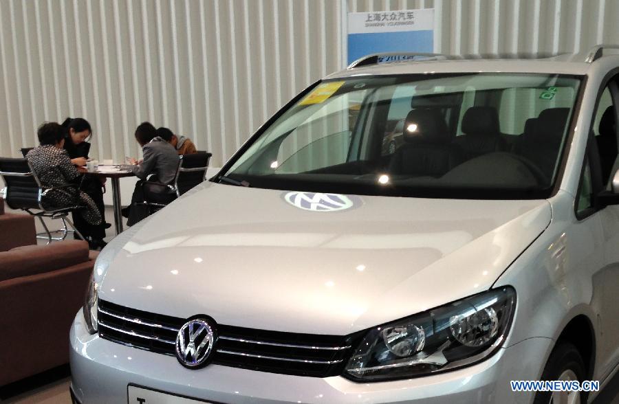 Customers inquire about auto prices at a Volkswagen 4S shop in Shanghai, east China, March 20, 2013. German automaker Volkswagen has agreed to recall 384,181 vehicles with defective gearboxes in China, the country's quality watchdog said on Wednesday. (Xinhua/Pei Xin) 