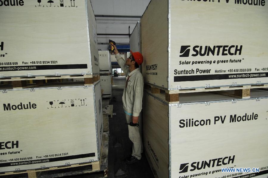 In this file photo taken on Sept. 26, 2011, a worker scans solar panel products for registration at Suntech Power in Wuxi, east China's Jiangsu Province. China's leading solar panel maker Suntech Power, a New York-listed private company based in Wuxi, declared bankruptcy on Wednesday. (Xinhua/Shen Peng) 
