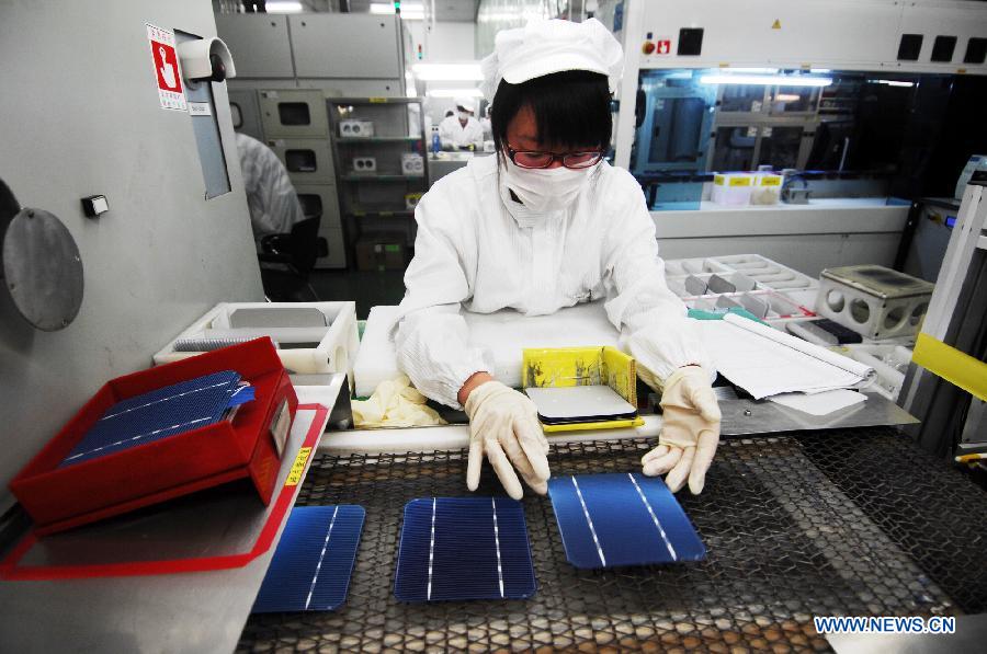 In this file photo taken on Sept. 26, 2011, a worker inspects solar panels on a production line at Suntech Power in Wuxi, east China's Jiangsu Province. China's leading solar panel maker Suntech Power, a New York-listed private company based in Wuxi, declared bankruptcy on Wednesday. (Xinhua/Shen Peng) 