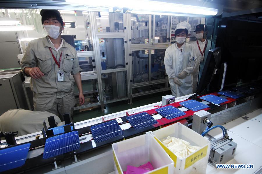In this file photo taken on Sept. 26, 2011, workers inspect solar panels on a production line at Suntech Power in Wuxi, east China's Jiangsu Province. China's leading solar panel maker Suntech Power, a New York-listed private company based in Wuxi, declared bankruptcy on Wednesday. (Xinhua/Shen Peng) 