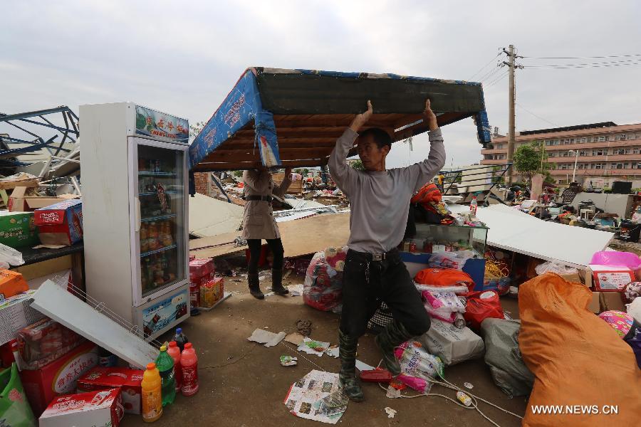 Locals salvage articles near a collapsed shed in Daoxian County, central China's Hunan Province, March 20, 2013. Three people were killed and 52 others were injured by a tornado that struck the county before dawn on Wednesday. The local meteorological observatory said the wind speed of the tornado reached 30.7 meters per second, a record for the observatory. (Xinhua/Guo Guoquan)