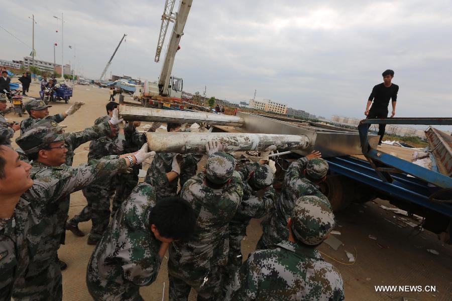 Rescuers clear wind-torn billboards in Daoxian County, central China's Hunan Province, March 20, 2013. Three people were killed and 52 others were injured by a tornado that struck the county before dawn on Wednesday. The local meteorological observatory said the wind speed of the tornado reached 30.7 meters per second, a record for the observatory. (Xinhua/Guo Guoquan)