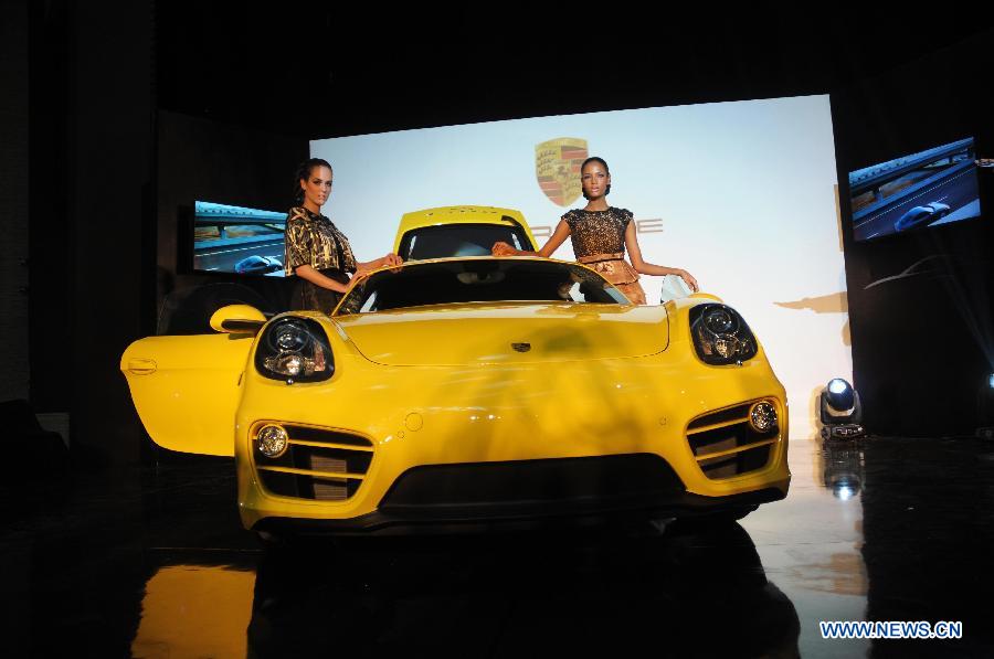 Models stand beside a Porsche Cayman at a launching ceremony in Jakarta, Indonesia, March 19, 2013. Porsche Indonesia launched Cayman and Cayman S on Tuesday. (Xinhua/Zulkarnain) 