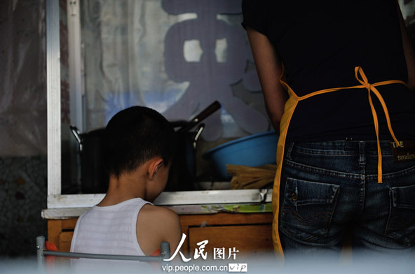 Li's son watches her mother working. Since their son was born 3 years ago, Zhao and Li feel their responsibility becomes heavier and heavier.(photo/vip.peolpe.com.cn)
