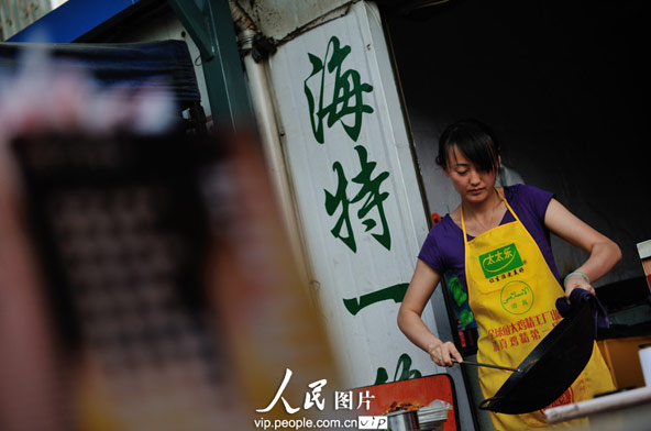 Li cooks in the restaurant.(photo/vip.peolpe.com.cn)