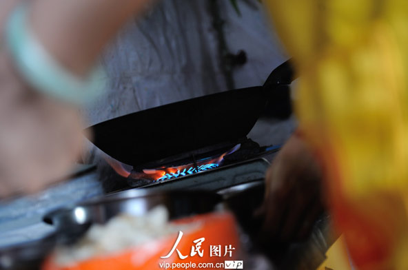 Zhao cooks in the restaurant. (photo/vip.peolpe.com.cn)