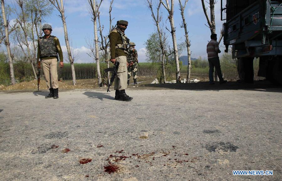 Indian border guards stand close to the blood stains near the site of militant attack in Srinagar, summer capital of Indian-controlled Kashmir, March 21, 2013. At least three border guards of India's Border Security Force (BSF) were wounded Thursday after gunmen ambushed their convoy in Indian-controlled Kashmir, police said. (Xinhua/Javed Dar)