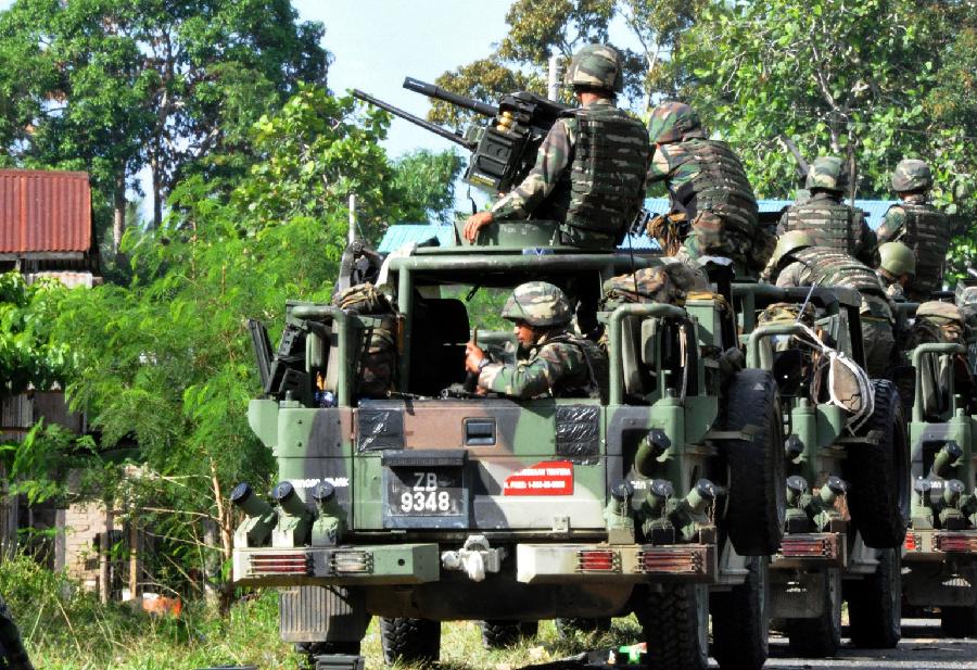 Malaysian security forces attend the all-out attack in Sabah of North Borneo in Malaysia, March 19, 2013. Senior Malaysian security officials on Monday expressed confidence to end the deadly standoff in Sabah. Some 200 of Sultan Jamalul Kiram III's followers landed in Sabah last month to stake a territorial claim on the land. Ten security forces and more than 60 gunmen were killed during the month-long standoff. Malaysian security forces launched an all-out attack on March 5 after negotiations broke down. (Xinhua)