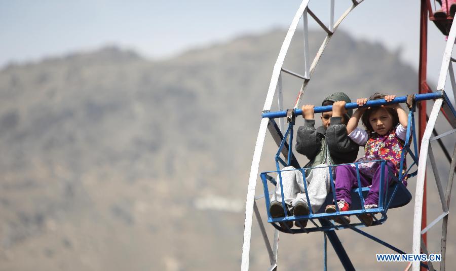 Two Afghan children enjoy the sky wheel during the celebration of Nowruz festival in Kabul, Afghanistan, March 21, 2013. Afghans celebrate the Nowruz festival as the first day of the year in Persian calendar. (Xinhua/Ahmad Massoud)