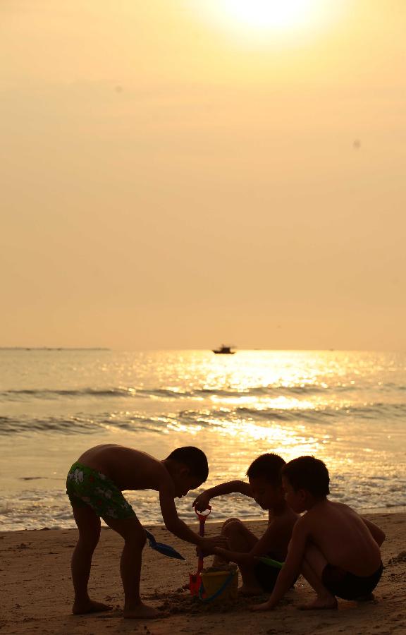 Children play at the seaside in Sanya, a tourist destination in south China's Hainan Province, March 20, 2013. (Xinhua/Chen Wenwu)