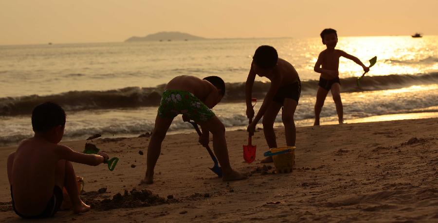 Children play at the seaside in Sanya, a tourist destination in south China's Hainan Province, March 20, 2013. (Xinhua/Chen Wenwu)