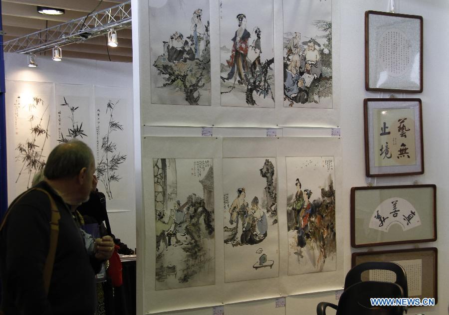 Visitors watch artworks by Chinese artists in New York City, the United States, on March 21, 2013, during the New York Art Expo which is the world's largest fine art trade show for 35 years. (Xinhua/Wang Chengyun) 