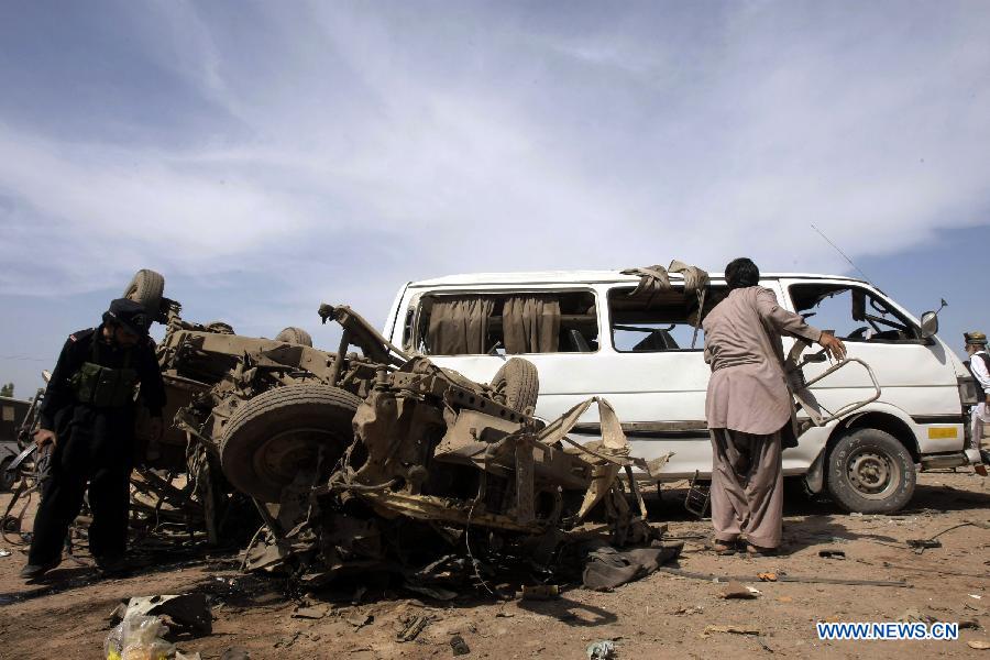 Security officials examine damaged vehicles at the site of a bomb attack at the Jalozai refugee camp in northwest Pakistan's Nowshera on March 21, 2013. At least 12 people were killed and 35 others injured when a bomb hit a refugee camp in Nowshera on Thursday morning, local officials said. (Xinhua Photo/Umar Qayyum)