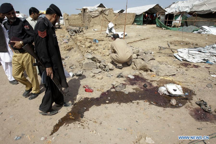 Security officials examine the site of a bomb attack at the Jalozai refugee camp in northwest Pakistan's Nowshera on March 21, 2013. At least 12 people were killed and 35 others injured when a bomb hit a refugee camp in Nowshera on Thursday morning, local officials said. (Xinhua Photo/Umar Qayyum)