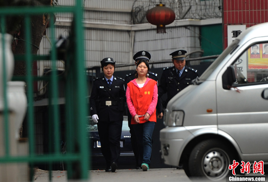 Zhang Guiying is transferred under police escort from Chongqing’s Shapingba District Detention Center on March 22, 2013. Zhang, girlfriend of serial homicidal thief Zhou Kehua, was sentenced to five years in jail on Friday by a court in southwest China's Chongqing Municipality. (Chinanews.com/Chen Chao) 