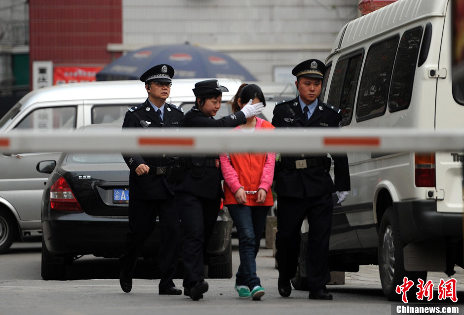 Zhang Guiying is transferred under police escort from Chongqing’s Shapingba District Detention Center on March 22, 2013. Zhang, girlfriend of serial homicidal thief Zhou Kehua, was sentenced to five years in jail on Friday by a court in southwest China's Chongqing Municipality. (Chinanews.com/Chen Chao) 