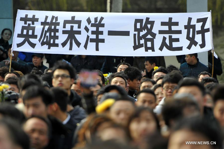 Citizens hold a banner saying "Farewell to Hero Song Yang" as they gather to bid farewell to Song Yang, the late bus driver who managed to protect passengers while he was having a stroke, in Jinan, capital of east China's Shandong Province, March 22, 2013. Song experienced a sudden brain hemorrhage while he was driving a long-distance bus carrying 33 passengers on a highway in Chiping County on the morning of March 9. He managed to slow down and park in the highway's breakdown lane, then tried his best to pull the handbrake and turn on the hazard lights. The 34-year-old driver passed away on March 20 despite being treated for days in the hospital. (Xinhua/Guo Xulei)
