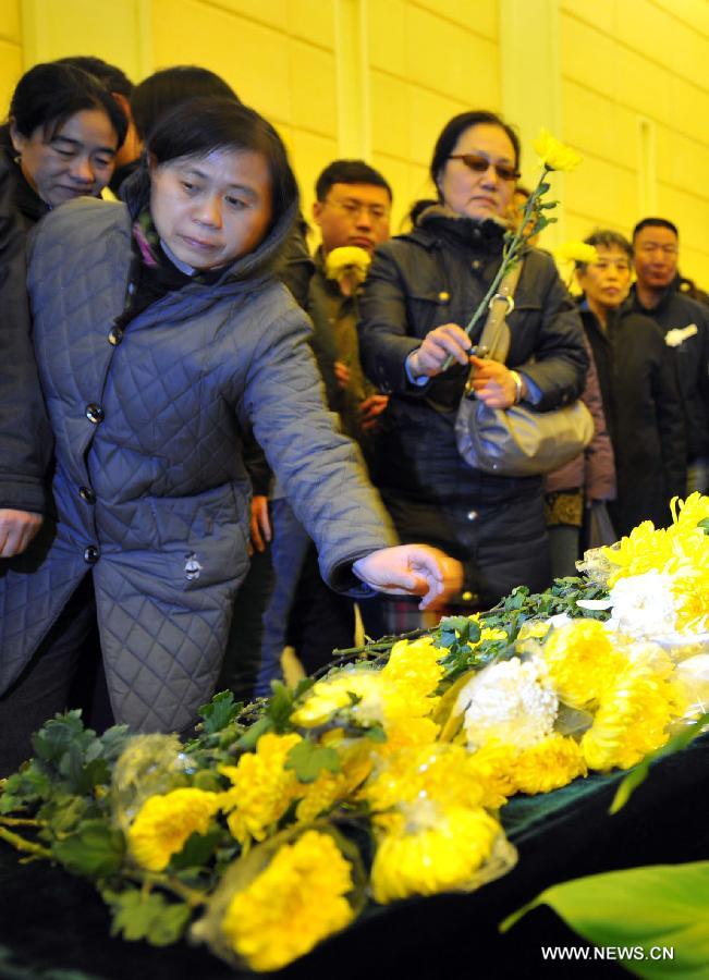 Citizens offer chrysanthemum flowers to bid farewell to Song Yang, the late bus driver who managed to protect passengers while he was having a stroke, in Jinan, capital of east China's Shandong Province, March 22, 2013. Song experienced a sudden brain hemorrhage while he was driving a long-distance bus carrying 33 passengers on a highway in Chiping County on the morning of March 9. He managed to slow down and park in the highway's breakdown lane, then tried his best to pull the handbrake and turn on the hazard lights. The 34-year-old driver passed away on March 20 despite being treated for days in the hospital. (Xinhua/Guo Xulei)