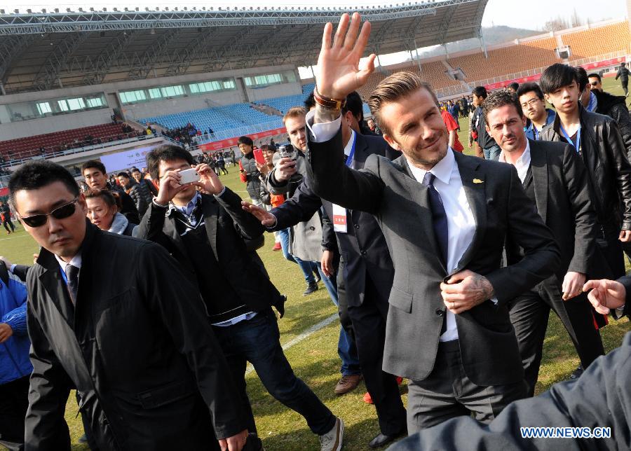 British soccer player David Beckham (front R) arrives at the Qingdao Tiantai Stadium in Qingdao, east China's Shandong Province, March 22, 2013. Beckham visited Qingdao Jonoon Soccer Club as the ambassador for the youth football program in China and the Chinese Super League Friday. (Xinhua/Li Ziheng)