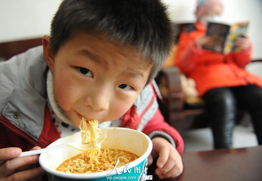 Zishuo eats as much as he can to gain weight for the surgery to save his sister, Mar. 4, 2013. (photo/vip.people.com.cn)