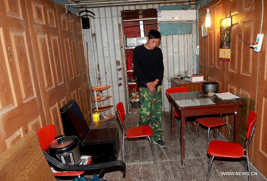 A tenant visits his landlord's container apartment in Sanlin Town in suburban Shanghai, east China, March 22, 2013. With a monthly rent of 500 yuan (about 80 U.S. dollars) for each container, three migrant worker families settled into their low-cost homes converted from abandoned containers in the metropolis. (Xinhua/Pei Xin) 