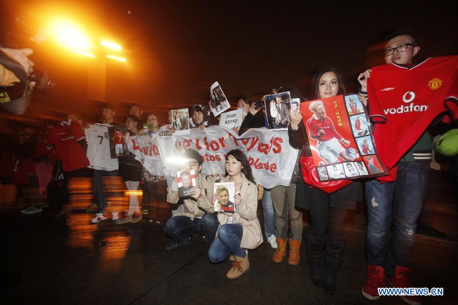 Fans hold pictures and banners as they wait for the arrival of superstar David Beckham at Wuhan Tianhe International Airport in Wuhan, capital of central China's Hubei Province, March 22, 2013. Beckham arrived in Wuhan as the ambassador for the Chinese Super League (CSL) and the Youth Football Program, (Xinhua) 