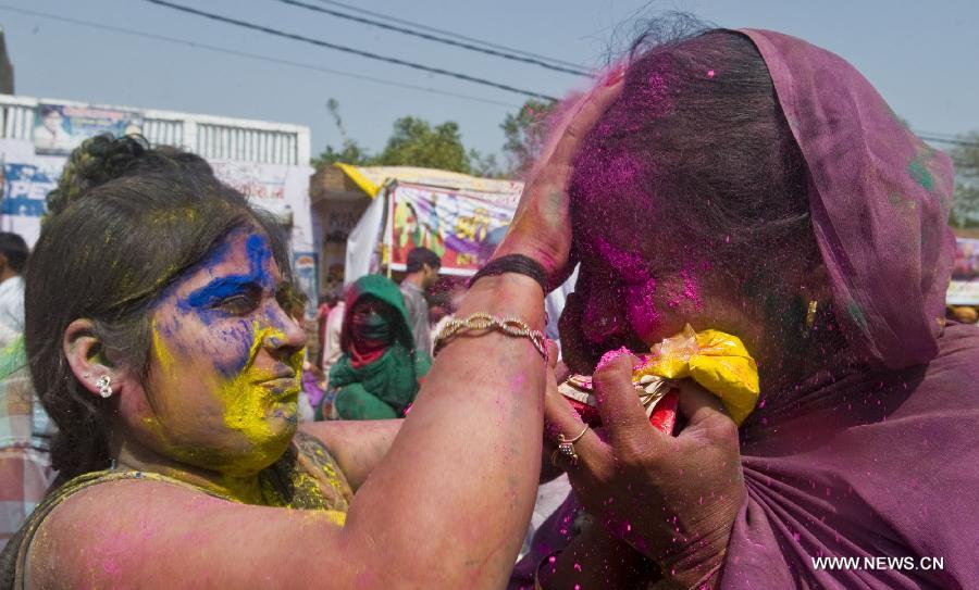 Indian women smear each others' face with colored powder during Latthmaar Holi festival at the Radha Rani temple in Barsana near Mathura city of Indian state Uttar Pradesh, March 21, 2013. (Xinhua/Tumpa Mondal)