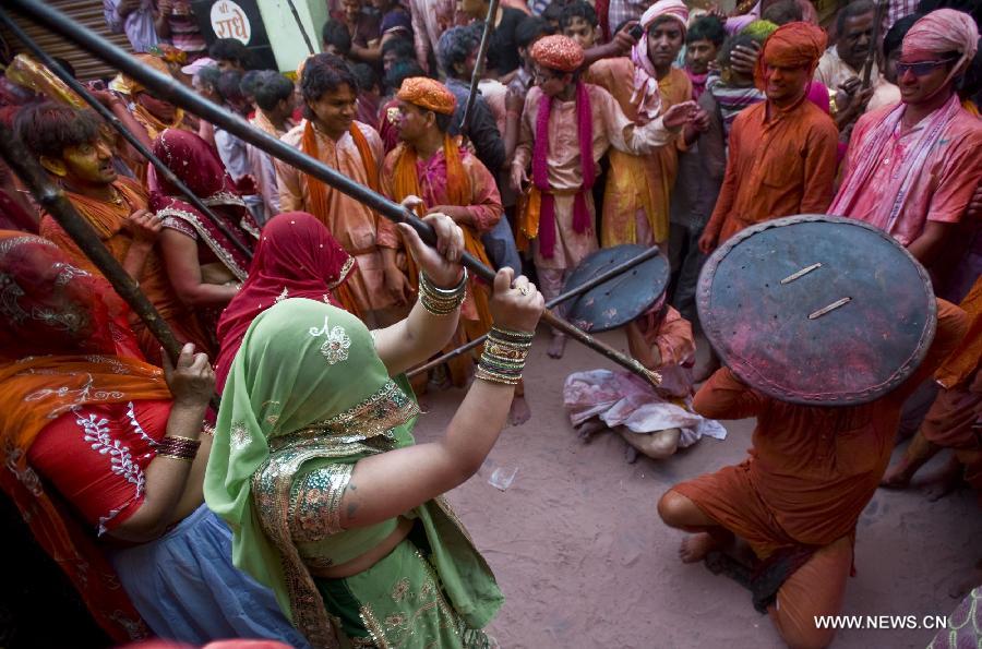 Indian women beat men with sticks during Latthmaar Holi festival at the Radha Rani temple in Barsana near Mathura city of Indian state Uttar Pradesh, March 21, 2013. (Xinhua/Tumpa Mondal)