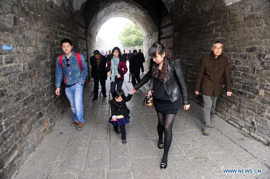 Tourists walk on the ancient city wall in Xiangyang, central China's Hubei Province, March 21, 2013. (Xinhua/Li Xiaoguo)