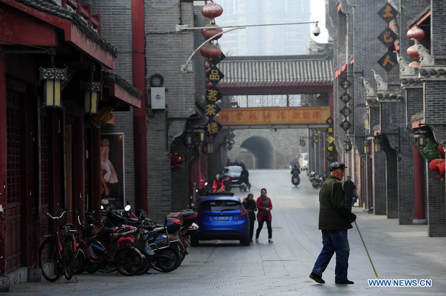 Citizens walk past an ancient street in Xiangyang, central China's Hubei Province, March 21, 2013. (Xinhua/Li Xiaoguo)