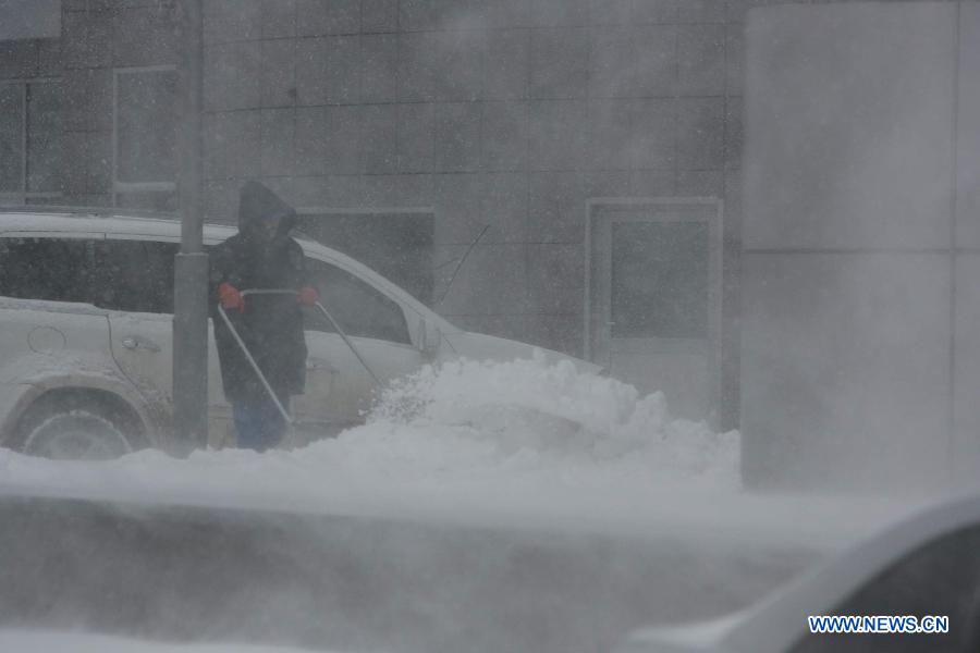 A dustman tries to clear a pavement in heavy snow in Kiev, capital of Ukraine, March 22, 2013. Heavy snow hit Kiev on Friday, disturbing traffic here. (Xinhua/Mu Liming) 