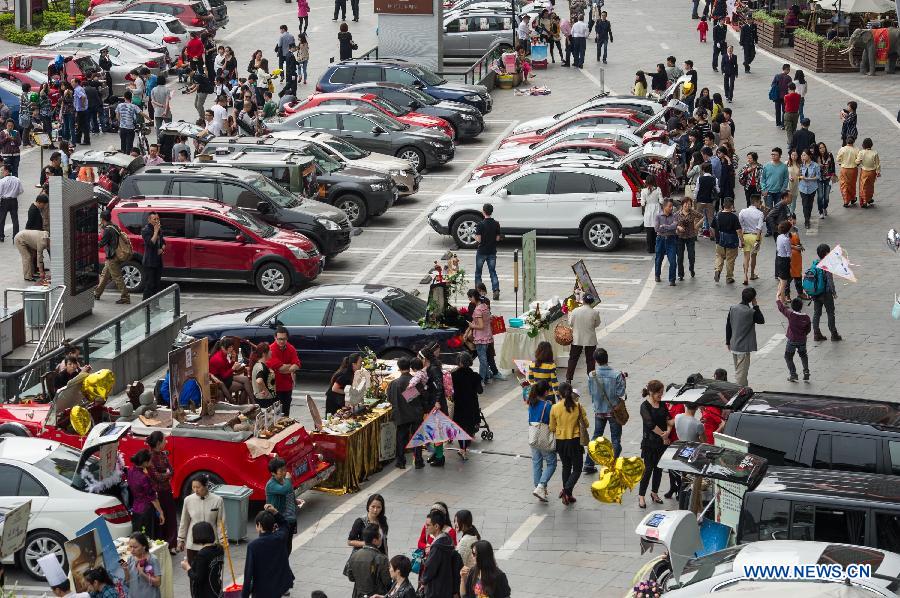 A weekend trunk market is held by a local auto club at Beibin Road in Chongqing, southwest China's municipality, March 23, 2013. (Xinhua/Chen Cheng) 