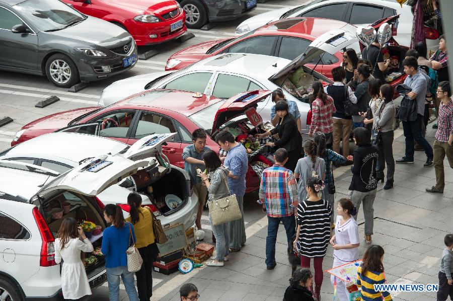 A weekend trunk market is held by a local auto club at Beibin Road in Chongqing, southwest China's municipality, March 23, 2013. (Xinhua/Chen Cheng) 