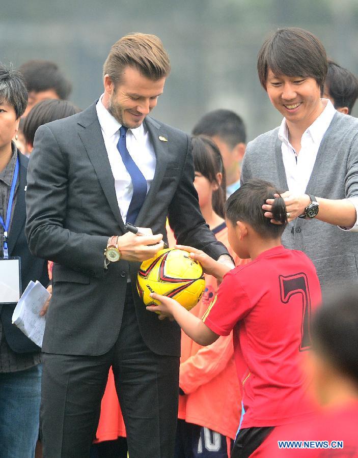 Football superstar, ambassador for the Chinese Super League (CSL) and the Youth Football Program, David Beckham (L) signs autograph at Hankou recreation and sports center in Wuhan, capital of central China's Hubei Province, March 23, 2013. (Xinhua/Cheng Min) 