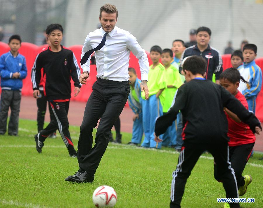 Football superstar, ambassador for the Chinese Super League (CSL) and the Youth Football Program, David Beckham (C) plays football with young players at Hankou recreation and sports center in Wuhan, capital of central China's Hubei Province, March 23, 2013. (Xinhua/Cheng Min) 