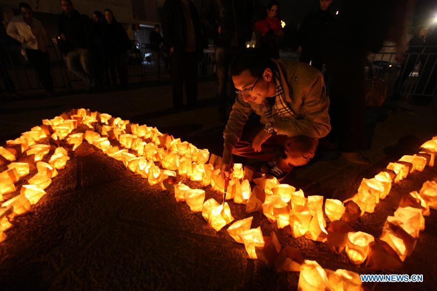 Palestinians gather around candles to mark the "Earth Hour" near the Church of Nativity in the West Bank city of Bethlehem on March 23, 2013. (Xinhua/Luay Sababa) 