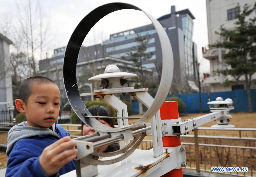 A student experiences a radiation sensor on the open day at China Meteorological Administration in Beijing, capital of China, March 23, 2013, the World Meteorological Day. (Xinhua/Chen Yehua) 