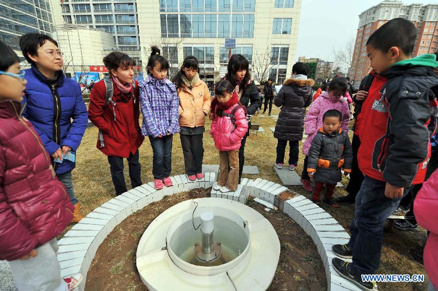 People gather to watch an evaporation measurement instrument on the open day at China Meteorological Administration in Beijing, capital of China, March 23, 2013, the World Meteorological Day. (Xinhua/Chen Yehua) 