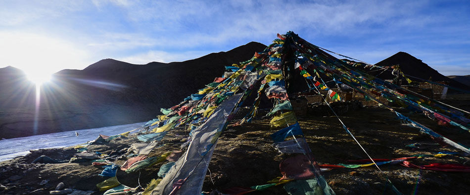 Morning light shines over the traditional Tibetan Buddhist prayer flags, Tanggula Mountains, March 17, 2013. (Xinhua/Wu Gang)