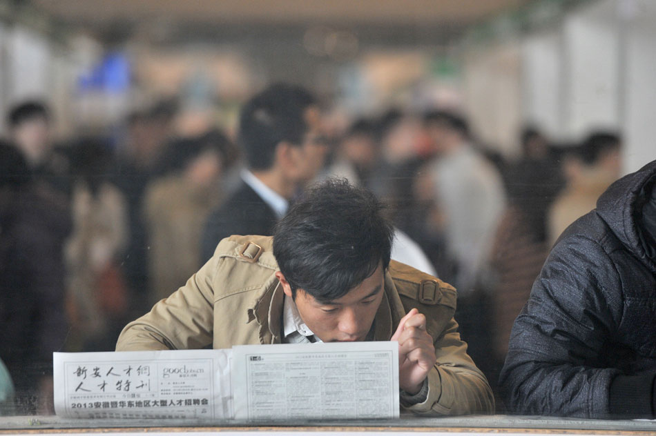A man reads job ads in a job fair held in Hefei, capital of east China’s Anhui province, March 23, 2013. (Xinhua/Guo Chen)