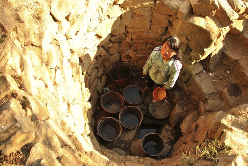 A water-fetching girl stands at the bottom of a well in Bijie, southwest China’s Guizhou province, March 16, 2013. Near half a million people in Guizhou live under the threat from a serious drought caused by high temperature and declined rainfall. (Xinhua/Yang Wenbin)