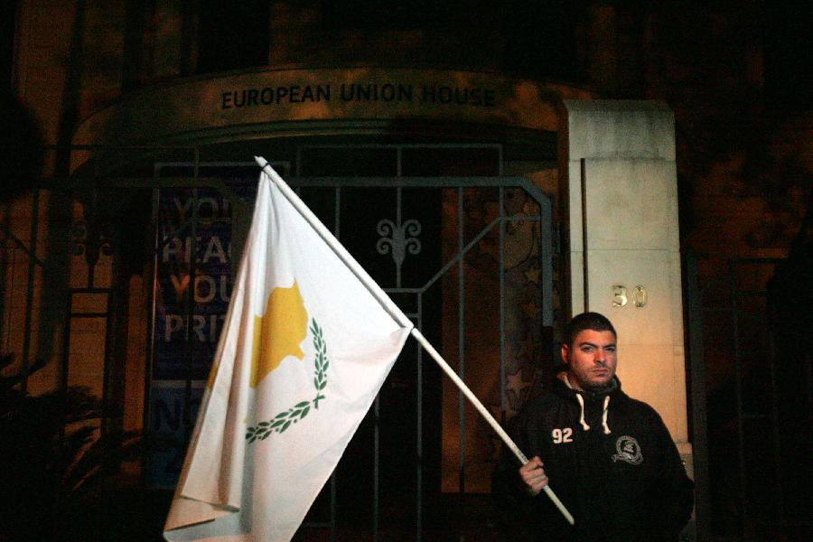 Cypriots protest in front of the office of the European Union, in Nicosia, Cyprus, on March 24, 2013. Some Cypriot banks have imposed a limit of 100 euros (130 U.S. dollars) on daily cash withdrawals from ATM machines, as crucial talks are underway in Brussels for a bailout accord. (Xinhua /Marios Lolos)